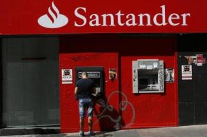 A man uses an ATM machine at a Santander bank branch in Madrid